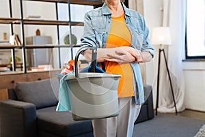 Resolute fit hardworking woman standing with equipment for cleaning