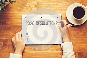 2020 Resolutions with a person holding a pen