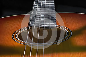 resonant hole in the soundboard of a guitar neck with strings photo