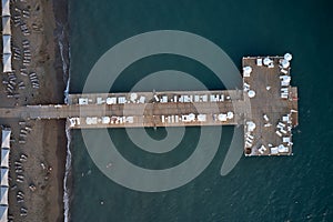 Resort coast with wooden pier in the sea, aerial view.