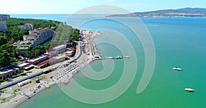 The Resort Of Gelendzhik. Flying over the beach from a bird`s eye view. A pebbly beach, rows of sun umbrellas and sun