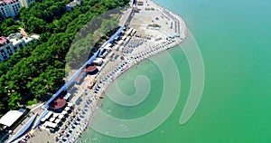 The Resort Of Gelendzhik. Flying over the beach from a bird`s eye view. A pebbly beach, rows of sun umbrellas and sun