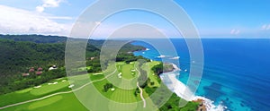 A resort golf course by the ocean, on a beautiful sunny day. A long hole par 5 hole by the sea shore. aerial shot.