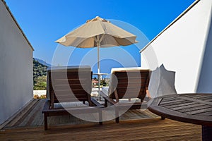 Resort landscape - beach umbrellas and chaise lounges against the background of the sea coast. Turkey. Oludeniz