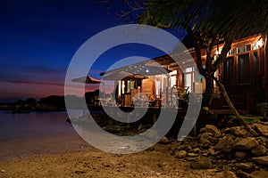 Resort by stone arch and sea at dusk, Ko Man Klang, Rayong