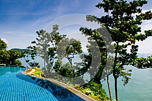 Infinity edge pool with blue sea and clear sky. Wide angle shot