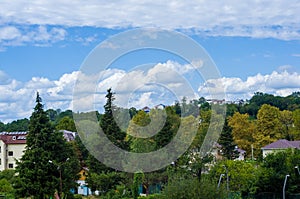 Resort village in mountain valley against the blue sky with clouds, summer landscape