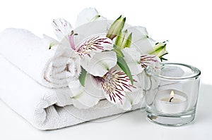 Resources for spa, white towel, candle and flower