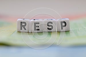 RESP letters on white blocks with bills on a clear background