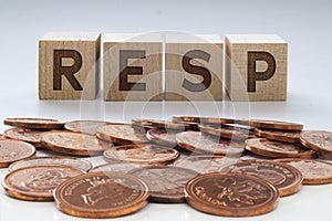 RESP letters on wooden blocks with coins on a clear background