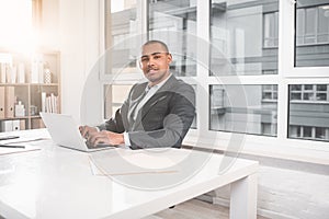 Respectable calm businessman making notes on laptop