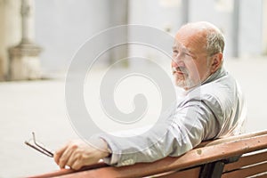 Respectable elderly man sitting on a bench photo