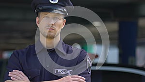 Respectable policeman in hat looking into camera, policing of city districts