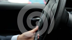 Respectable, responsible man driving car. The man holds the steering wheel. Close up