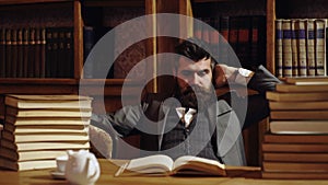 Respectable young man in the old library. Classic vintage interior. Businessman in classic suit read book. Old fashion