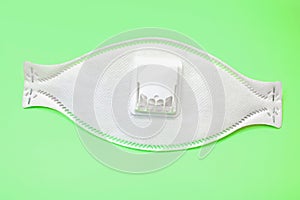 Respirator on green background. Device designed to protect the wearer from inhaling hazardous atmospheres photo