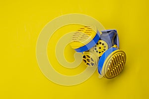 Respirator type half mask with replaceable filters on yellow background