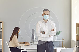 Responsible company employees prevent the spread of covid wearing face masks at work