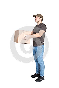 Responsible delivery man wearing cap, side view full length portrait, giving cardboard parcel box to customer, isolated on white