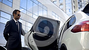 Responsible driver opening car door for his boss, luxury service, duties