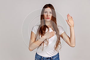 Responsible honest woman giving promise, making solemn vow in ceremonial tradition with raised hand