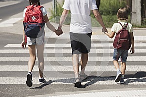 Responsible parent holding hands of children