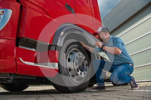 Responsible Truck Driver Checking Wheel Before Starting Route