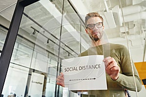 Responsible worker enforcing social distance rules at workplace