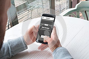 Responsive web site od design company on mobile phone in man hands