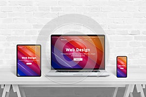 Responsive web site presentation concept on tablet, laptop and smart phone on white studio desk