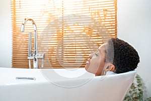 Rest, calm, pleasure, happiness and wellbeing concept. Attractive woman relaxing in foam bath.