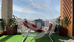 Rest in the city. woman in bikini relax on hammock on terrace