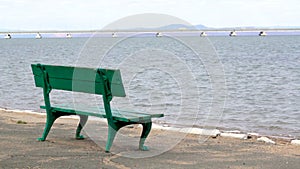 A rest park bench and a view from the shore of a low-water bridge from the Sedanka station to the De Friz peninsula across the Amu