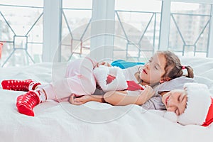 Two exhausted kids are sleeping, cuddling sweetly after new year party. photo