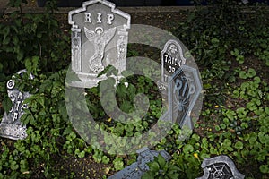 Rest in Peace RIP Gravestone Halloween Decoration with Skulls over green leaves in Halloween concept