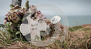 Rest in peace written in English on a cross