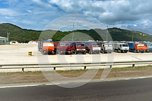 Rest on the road: trucks of different logistics companies parked under a blue cloudy sky