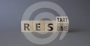 Restart and Resume symbol. Turned wooden cubes with words Resume and Restart. Beautiful grey background. Business and Restart and