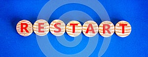 Restart and start symbol. The concept word Restart on wooden circles. Beautiful blue background, copy space. Business restart and