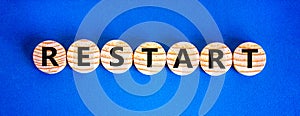 Restart and start symbol. The concept word Restart on wooden circles. Beautiful blue background, copy space. Business restart and