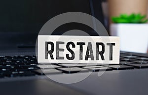 Restart and start symbol. The concept word Restart on wooden cubes. Beautiful orange table, orange background,