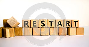 Restart and start symbol. The concept word Restart on wooden cubes. Beautiful white table, white background, copy space. Business