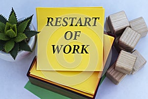 RESTART OF WORK - words on a yellow note paper on a light background with a cactus