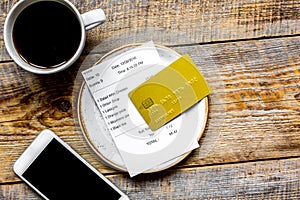 Restaurant bill, card and coffee on wooden table background top view space for text