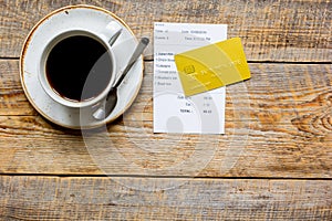 Restaurant bill, card and coffee on wooden table background top view space for text