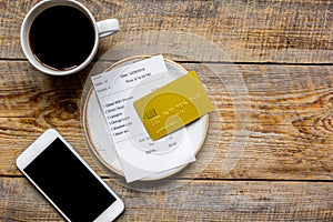 Restaurant bill, card and coffee on wooden table background top view space for text