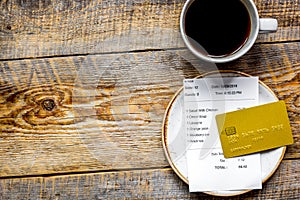 Restaurant bill paying by credit card for coffee on wooden table background top view mock-up