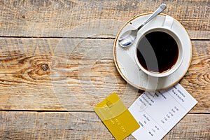 Restaurant bill paying by credit card and coffee on wooden table background top view mock-up