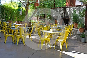 Restaurant courtyard with yellow chairs under the trees