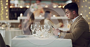 Restaurant, date and man waiting with phone at the table, sitting alone and frustrated with online dating. Reading